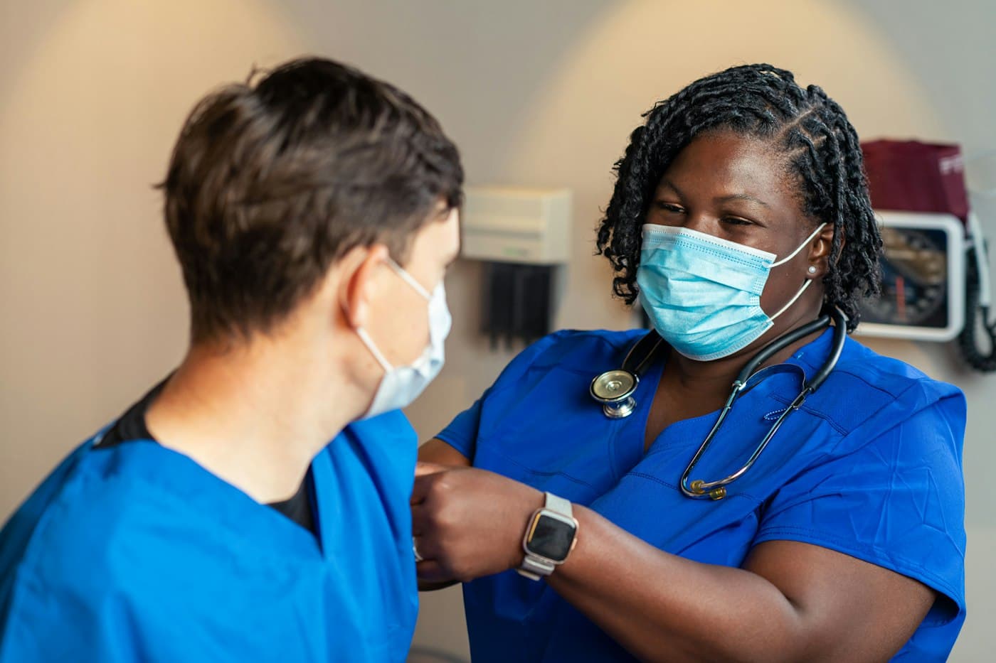 Nurse in blue scrubs with a colleague in a clinic