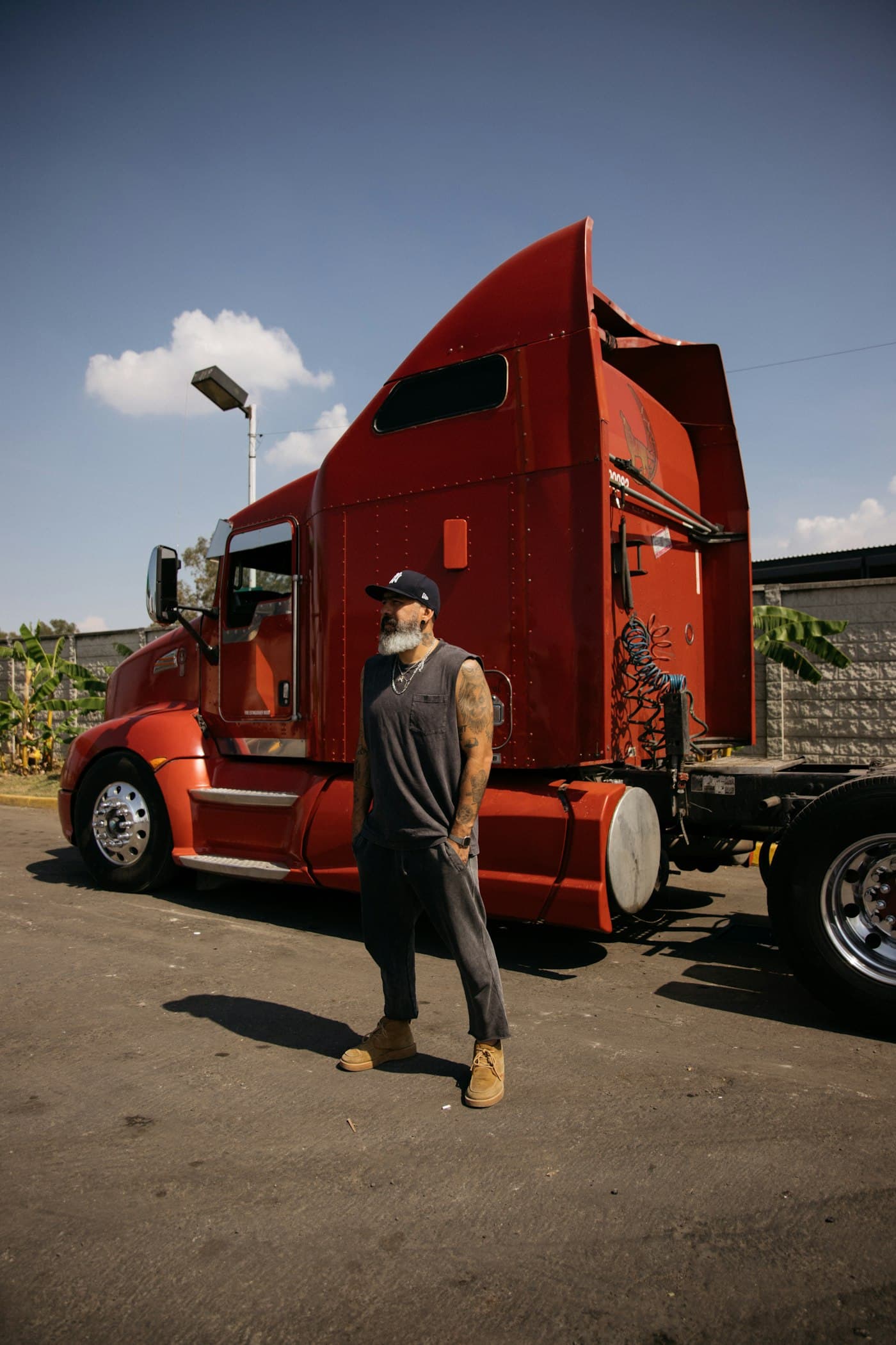 Driver standing beside a red semi-truck
